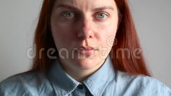 一个穿着蓝色衬衫的年轻红发女孩咳嗽得厉害视频的预览图