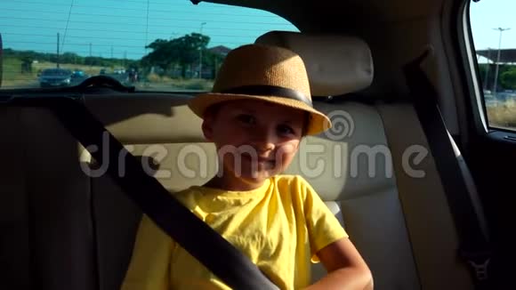 戴帽子的小男孩正坐在车后座上微笑着视频的预览图