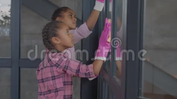 女孩用清洁用品清洗窗户玻璃视频的预览图