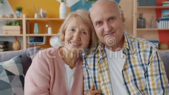 幸福家庭的肖像老人夫妻在家中的沙发上微笑放松视频的预览图