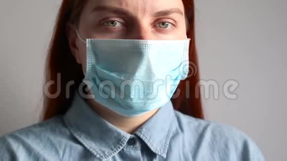 戴着医疗面具的女孩在灰色的墙上视频的预览图