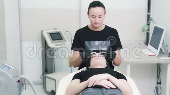 美容师在面部治疗前对女性眼睛戴上防护眼镜视频的预览图