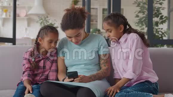 快乐的妈妈和孩子在手机上建立联系视频的预览图