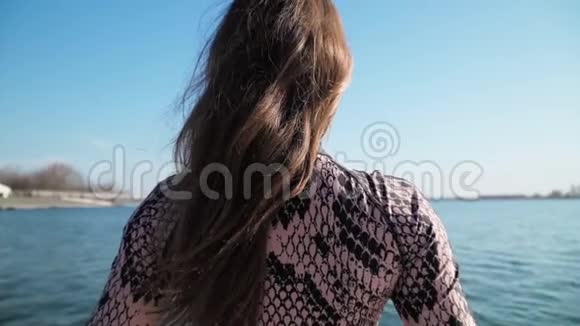 运动苗条的年轻女孩坐在美丽的蓝色湖水的背景下分裂户外瑜伽课视频的预览图