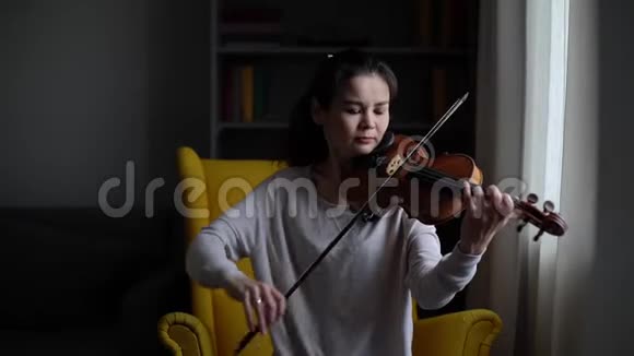 年轻女子缓慢地拉小提琴视频的预览图