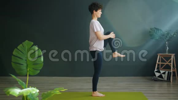 迷人的女性成人在健康工作室做瑜伽平衡单腿放松视频的预览图