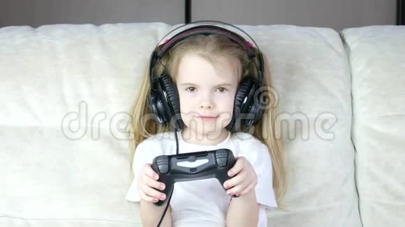 一个带着耳机玩的孩子快乐的小女孩玩电子游戏视频的预览图