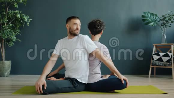 在健身中心坐在一起享受双人瑜伽的男女慢动作视频的预览图