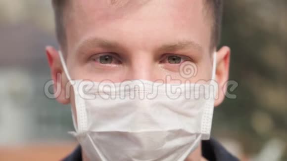 戴医疗面具的人的肖像他的眼睛在浇水看着相机COVID19和2019年冠状病毒概念视频的预览图