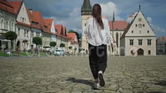 旅游妇女在斯洛伐克巴尔德乔夫的市政厅广场上奔跑视频的预览图