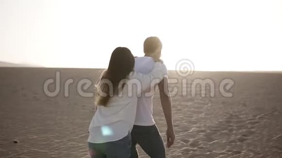 快乐可爱的成年夫妇穿着白色衬衫和牛仔裤男人背着女朋友玩得开心视频的预览图
