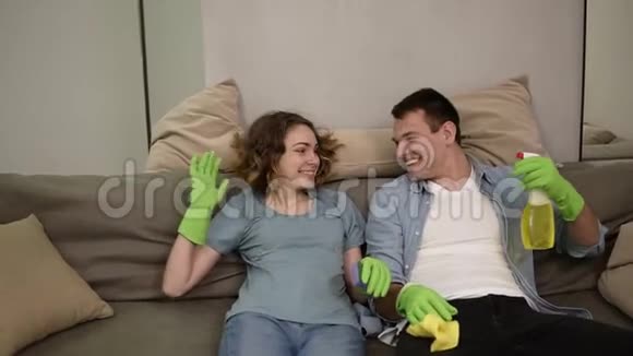 漂亮的年轻女人和一个戴绿色橡胶手套的男人一家人一起打扫房子开心快乐视频的预览图
