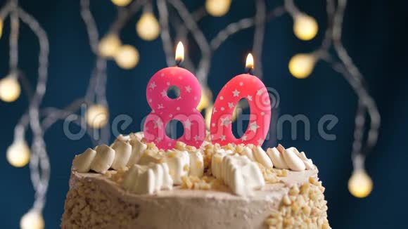 生日蛋糕80号粉红色燃烧蜡烛在蓝色的背景上蜡烛吹灭了慢速运动和特写镜头视频的预览图