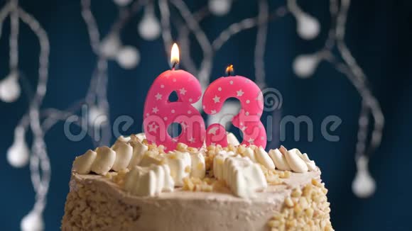生日蛋糕有63个数字粉红色燃烧蜡烛在蓝色的背景上蜡烛吹灭了慢速运动和特写镜头视频的预览图