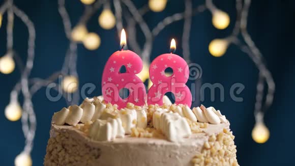 生日蛋糕上面有68个数字的粉红色燃烧蜡烛在蓝色的背景上蜡烛吹灭了慢速运动和特写镜头视频的预览图