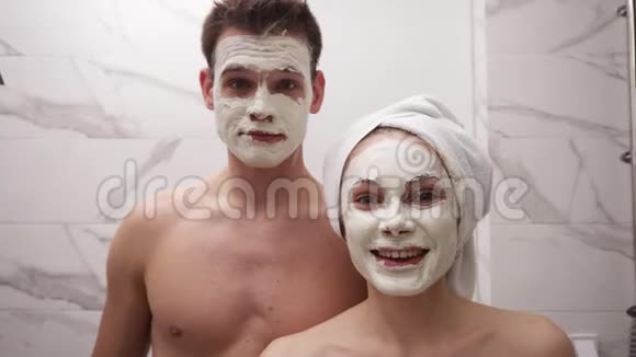 一对疯狂有趣的夫妇在洗澡后站在浴室的镜子前男人袒胸女孩头上戴白色毛巾视频的预览图