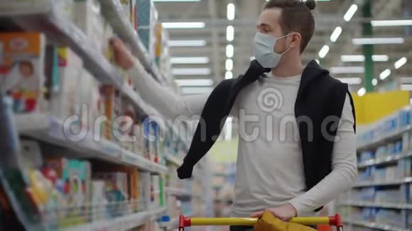 冠状病毒流行期间在超市购物男士戴面罩视频的预览图