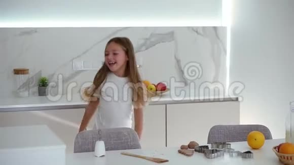 快乐美丽的小女孩在现代厨房跳舞玩有趣的舞蹈动作长发微笑的女孩视频的预览图