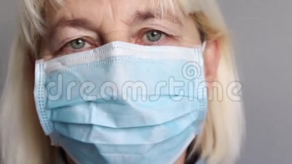戴着医用面具的女人看着镜头冠状病毒视频的预览图