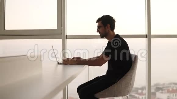 商务人员在远程工作场所慢动作使用笔记本电脑的侧面视图在电脑上工作的自由职业者视频的预览图