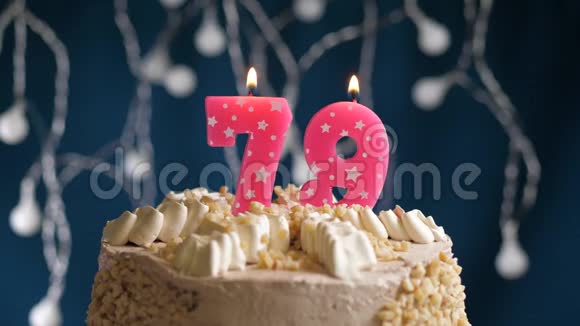 生日蛋糕上有79个数字的粉红色燃烧蜡烛在蓝色的背景上蜡烛吹灭了慢速运动和特写镜头视频的预览图