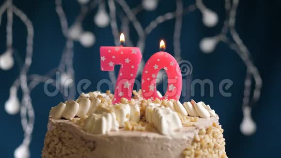 生日蛋糕70号粉红色燃烧的蜡烛在蓝色的背景上蜡烛吹灭了慢速运动和特写镜头视频的预览图