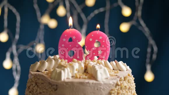 生日蛋糕上有69个数字的粉红色燃烧蜡烛在蓝色的背景上蜡烛吹灭了慢速运动和特写镜头视频的预览图