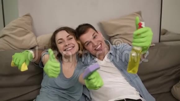 一对年轻快乐的夫妇戴着绿色橡胶手套的肖像一家人一起打扫房子快乐视频的预览图