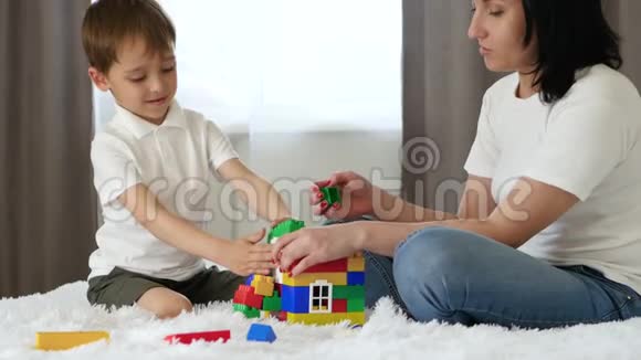 快乐的孩子花时间和保姆玩妈妈坐在房间的床上一个母亲和一个小男孩从视频的预览图