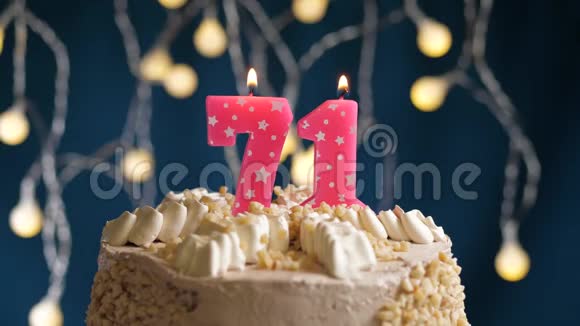 生日蛋糕71号粉红色燃烧蜡烛在蓝色的背景上蜡烛吹灭了慢速运动和特写镜头视频的预览图