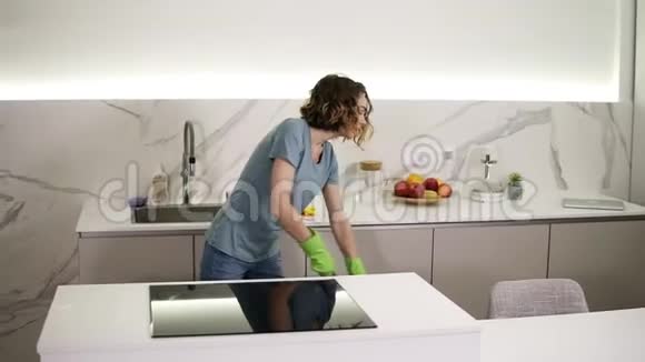 快乐的年轻女人可爱的家庭主妇正在厨房里用防护手套洗地板享受家务人民视频的预览图