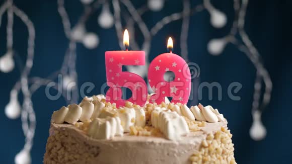 生日蛋糕上有59个数字粉红色燃烧蜡烛在蓝色的背景上蜡烛吹灭了慢速运动和特写镜头视频的预览图