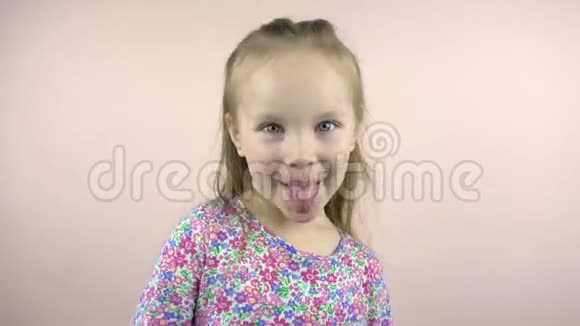 开心的小童女看着镜头鬼脸露出舌头视频的预览图