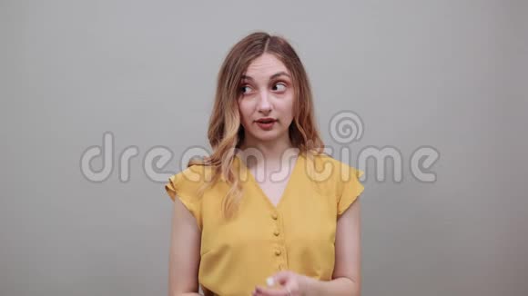 害怕的年轻女人咬指甲失望地穿着时尚的黄色衬衫视频的预览图