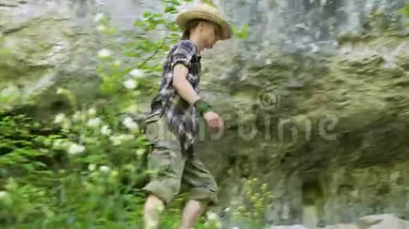 戴帽子的年轻人赤脚走在山林路上向前看视频的预览图