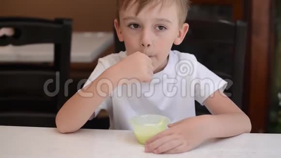 可爱的男孩在咖啡馆露台吃冰淇淋快乐的孩子一边吃冰淇淋一边微笑失去孩子的婴儿牙齿快乐健康的辣椒视频的预览图