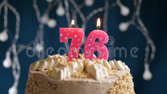 生日蛋糕76号粉红色燃烧的蜡烛在蓝色的背景上蜡烛吹灭了慢速运动和特写镜头视频的预览图