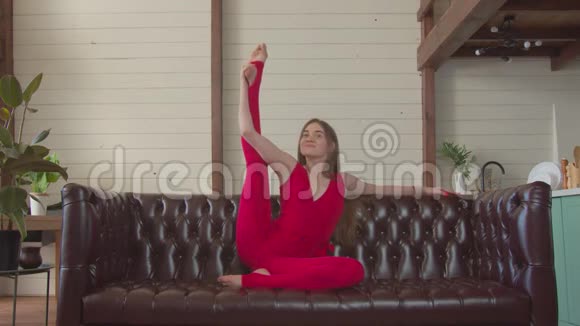 优雅的女人在沙发上练瑜伽姿势视频的预览图