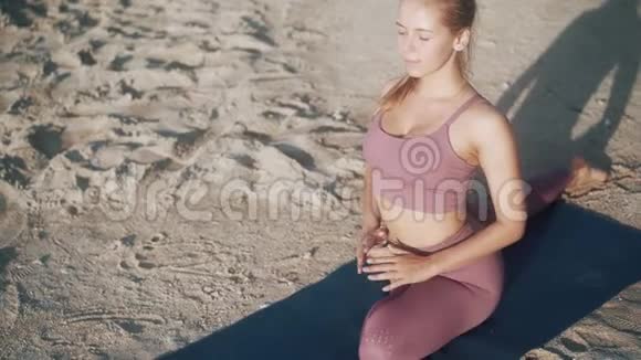扎马尾的女孩伸展身体做鸽子瑜伽姿势视频的预览图