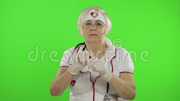 年长的女医生把药丸倒进她的手里女护士病毒防护视频的预览图