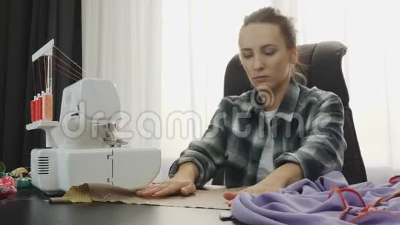 女人在裁缝工作室的桌子上用布料和剪刀工作女人做手工服装缝纫面料车间F视频的预览图