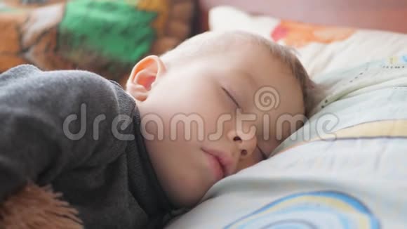 安静的小男孩睡觉时躺在床上家庭母健康和护理的概念视频的预览图