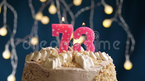 生日蛋糕蓝色背景上有73号粉红色蜡烛蜡烛吹灭了慢镜头和特写镜头视频的预览图