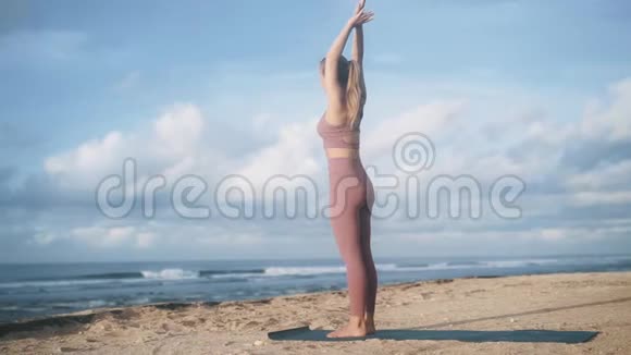 站在海边的苗条女子做半月瑜伽姿势视频的预览图