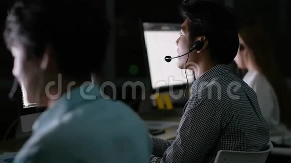 接线员与他的团队一起工作在晚上支持客户视频的预览图
