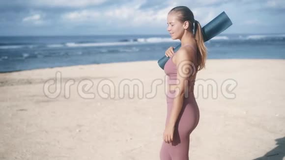 穿着紫罗兰色运动服的快乐女孩走在沙滩上视频的预览图