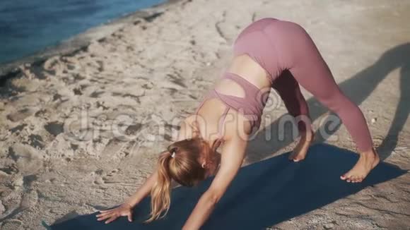 穿紫色运动服的金发女孩练习瑜伽姿势视频的预览图