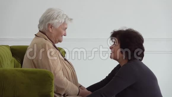 美丽的女人在白屋子里和年迈的母亲说话视频的预览图