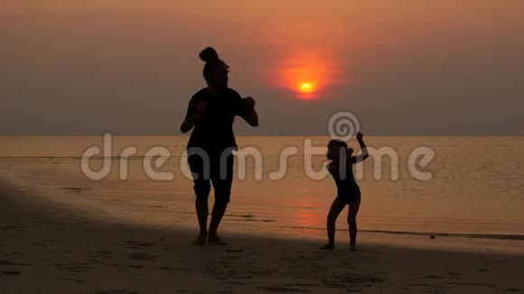 爸爸和孩子在日落时在海滩上跳视频的预览图