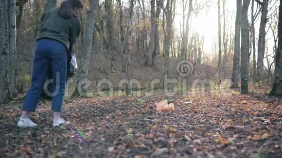 将秋季的垃圾收集在垃圾袋中森林中的一个女人拯救了自然使其免于毁灭世界视频的预览图